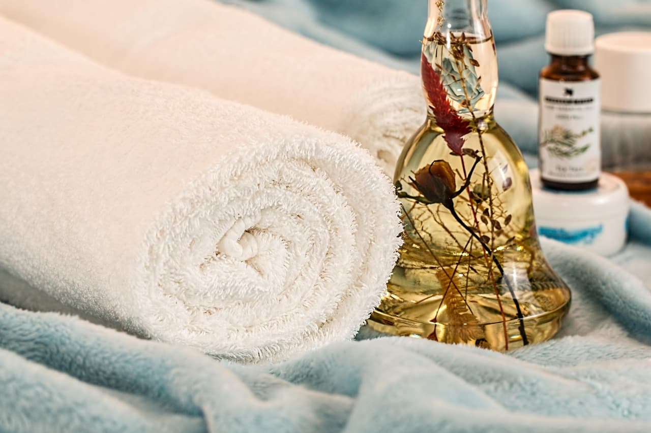 Rolled white towels and oils, ready for a facial