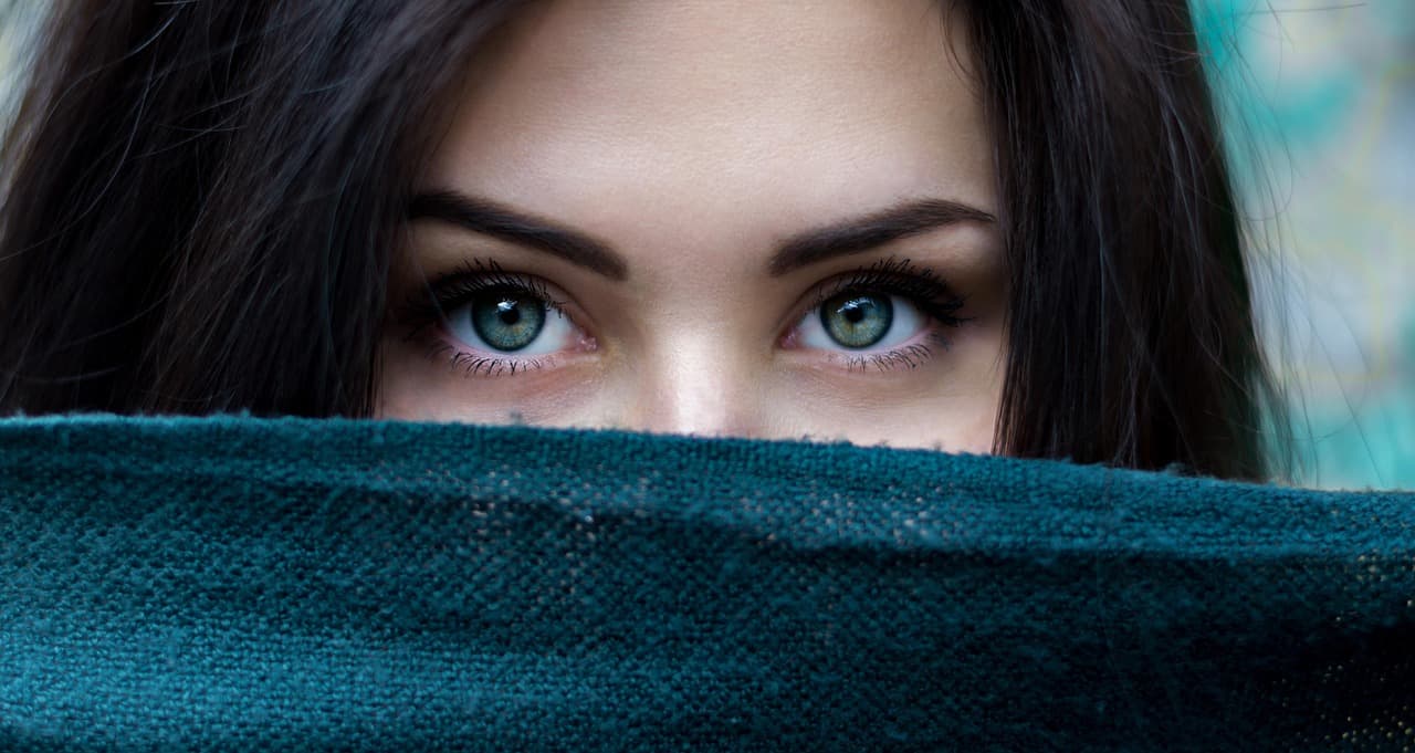 Defined dark brows above green eyes